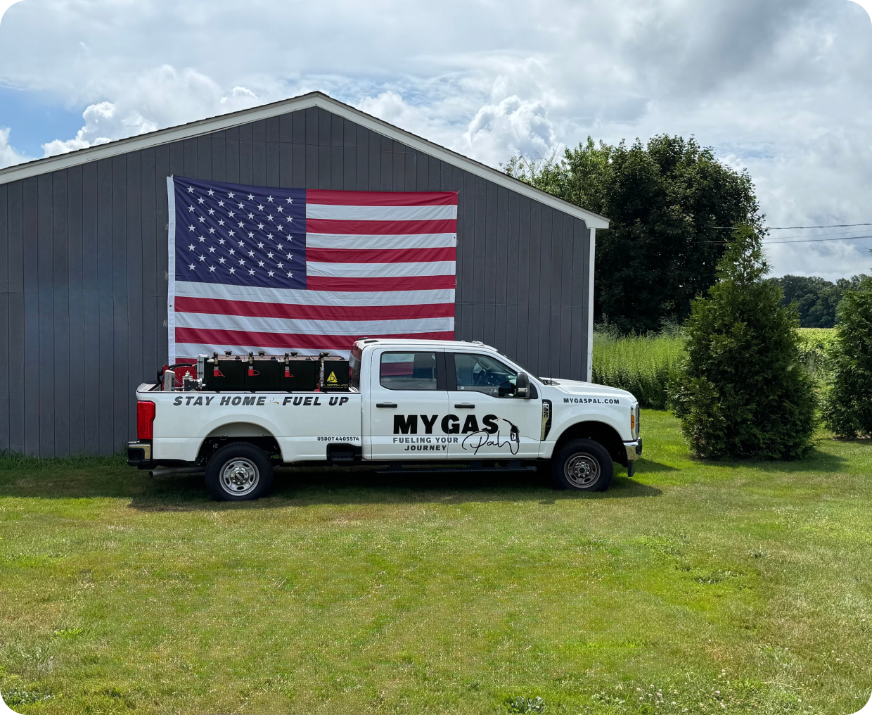 Fuel delivery truck beside large flag
